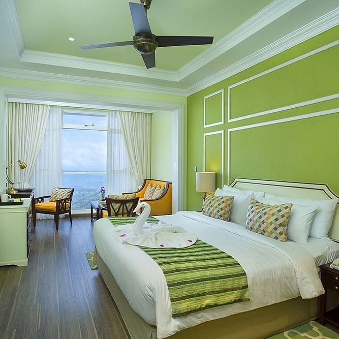 Spacious bed with furniture for seating, a bedside table, and a wall-mounted television