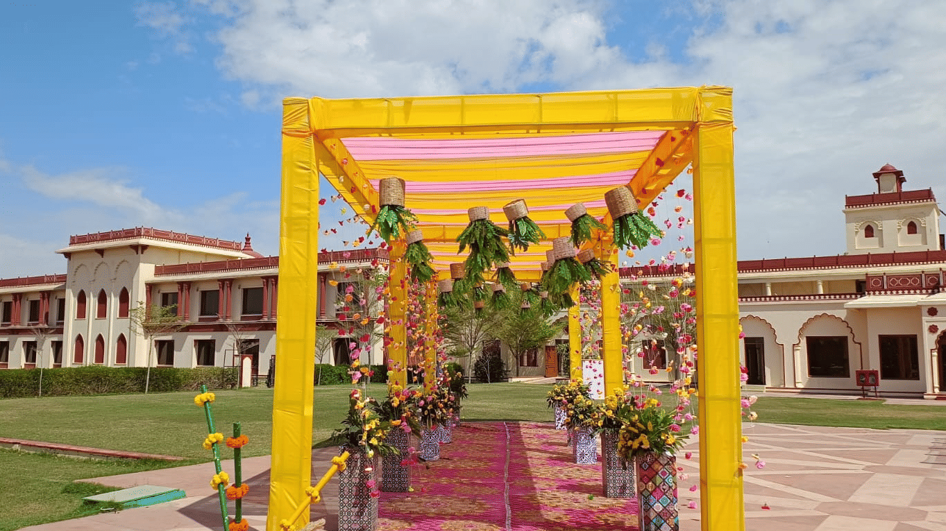 Decorated entrance to The Ummed Jodhpur, with a colorful canopy, flower arrangements, and a view of the palace in the background.