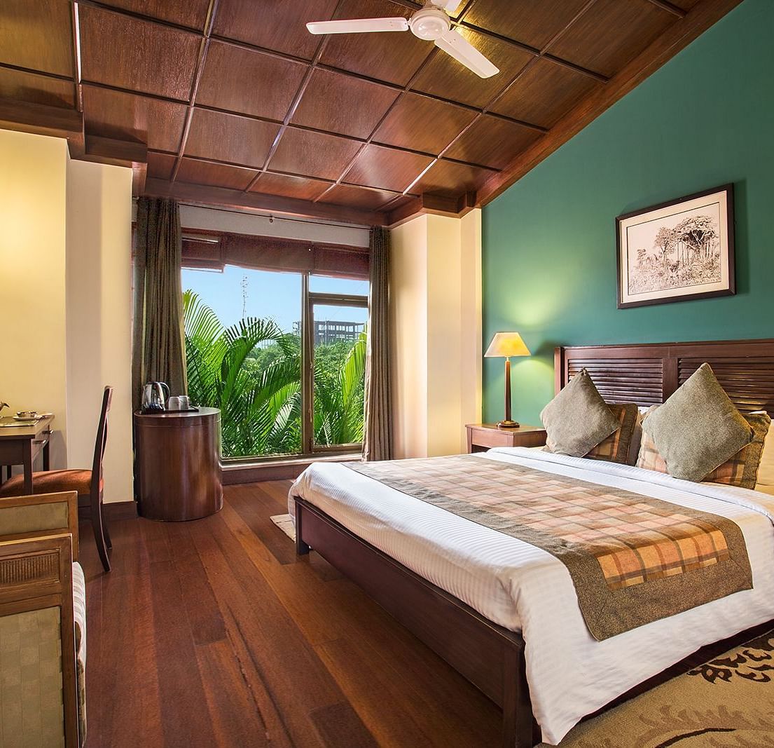 An image of a bedroom with king size bed, bedside table and lamp,  flat TV screen,  a cabinet , fan, and an open window - The Riverview Retreat, Corbett