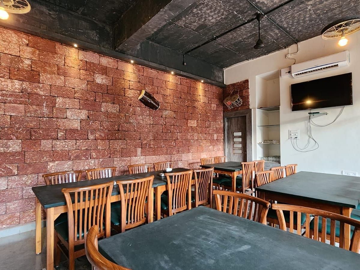 There are tables and chairs around them with warm lighting and a wall-mounted TV at SeaFort Beach Resort