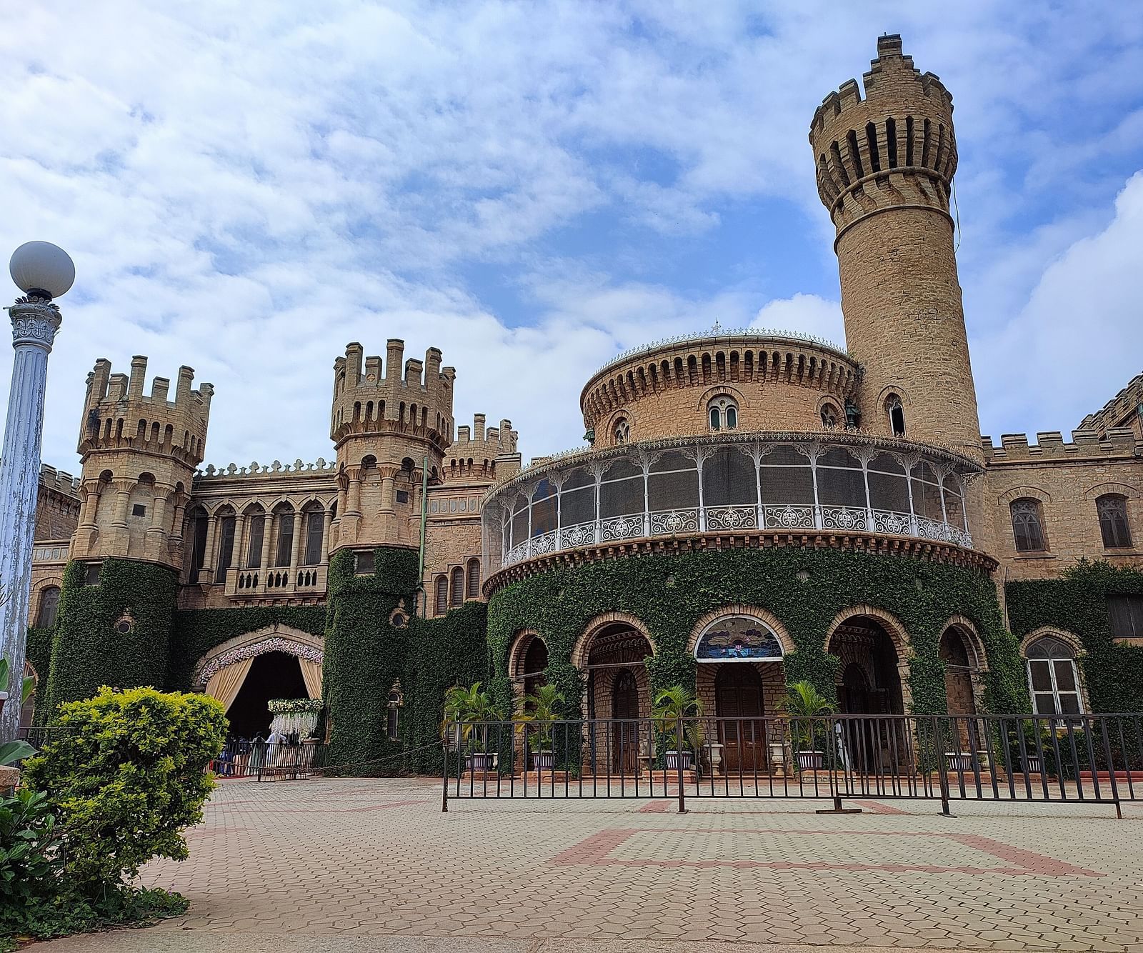 Facade of Bangalore Palace with climbers covering the bottom part of the structure.