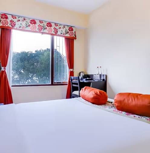 A view of a king size bed in front of TV at Summit Namnang Courtyard and Spa