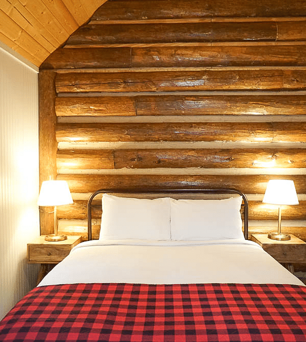 A room with a double bed and side tables with night lights at Shaver Lake Village Hotel.