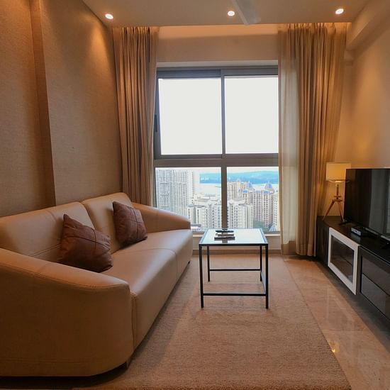 A living room featuring a sofa a coffee table and a TV - Maxxvalue Apartment Powai
