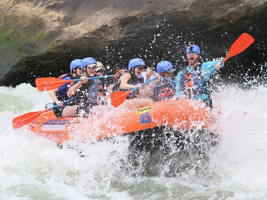 alt-text Close-up of the same group of rafters, splashing through a particularly rough section of the river, emphasizing the excitement and challenge of the activity.