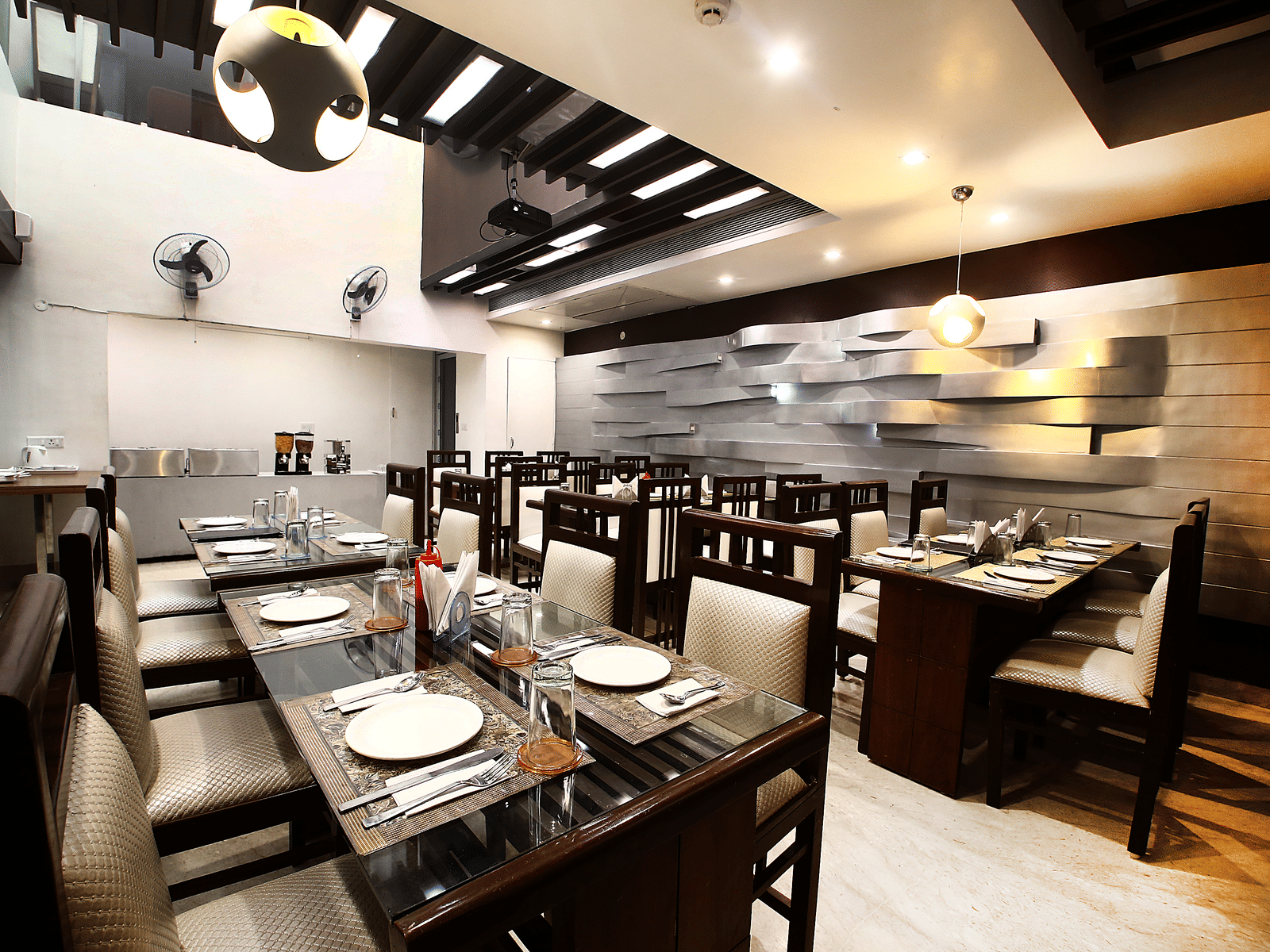 Dining area with neatly arranged tables and chairs at Hotel Emerald, Chandigarh