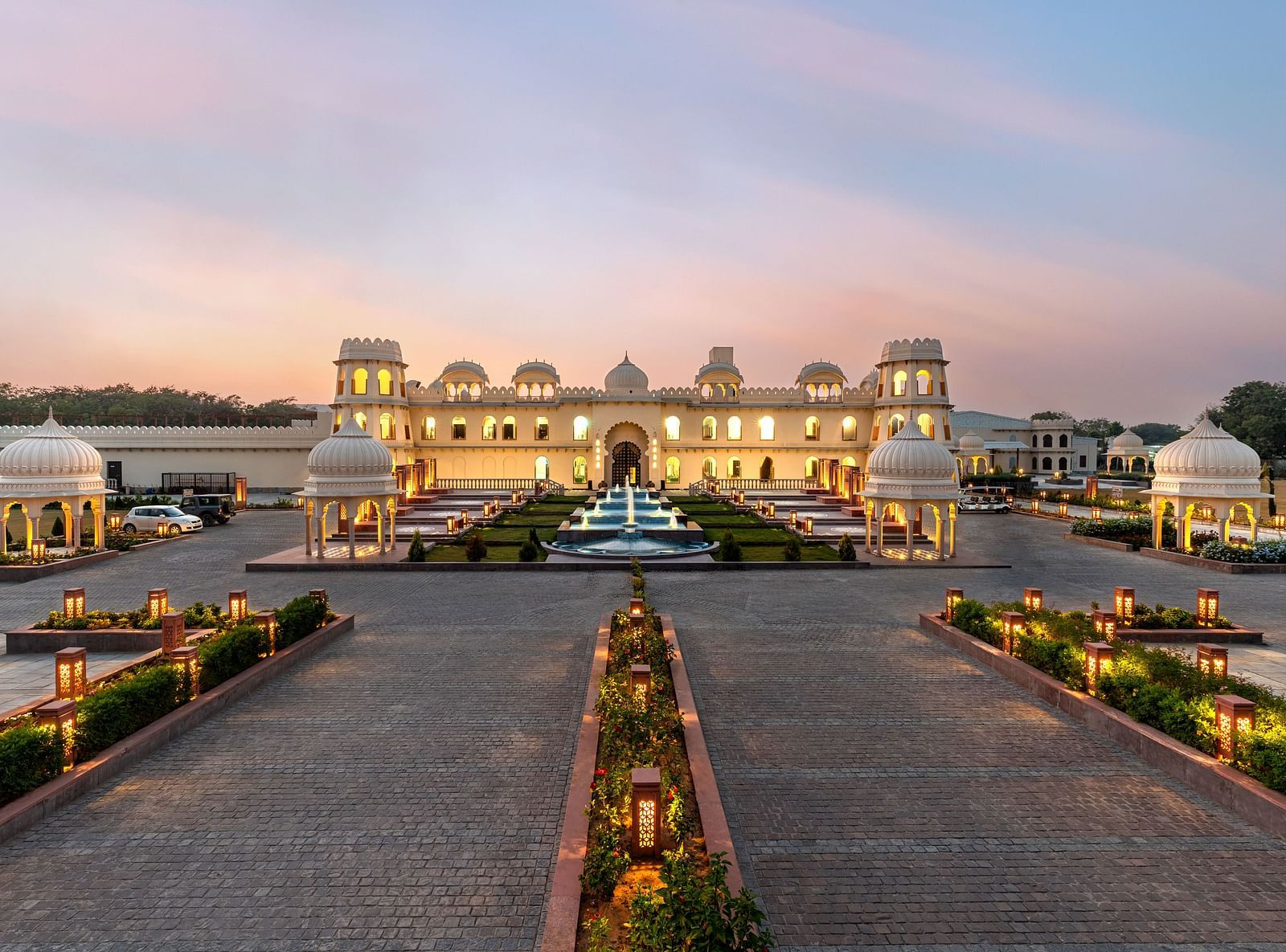 Exterior view of Kesar Bagh Palace building at sunset with landscaped pathways.
