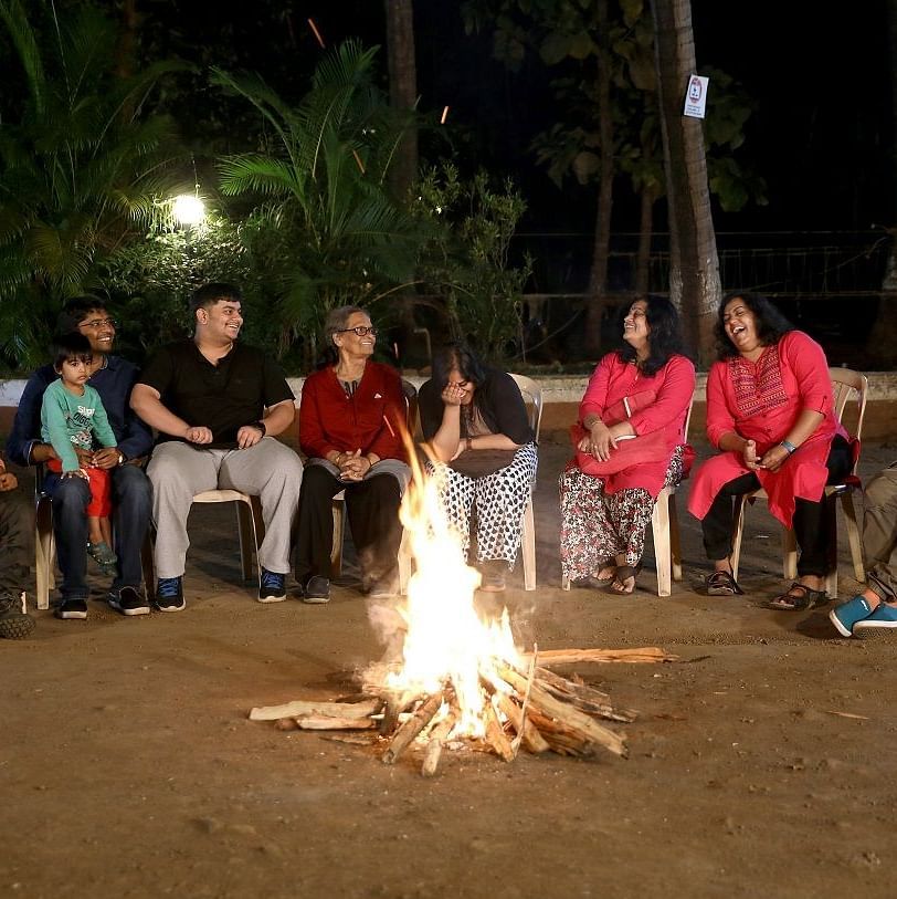 Campfire - Sajan - a group of 8 peopl sitting on chairs surrounding a camp fire and enjoying long talks.