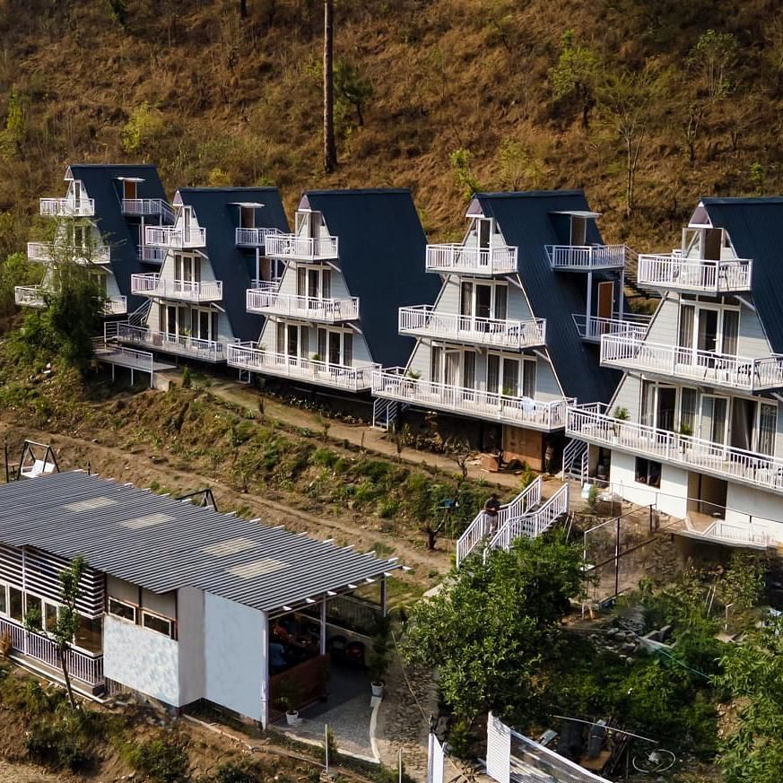 An aerial daytime view of a resort complex with multiple buildings set into a hillside landscape.