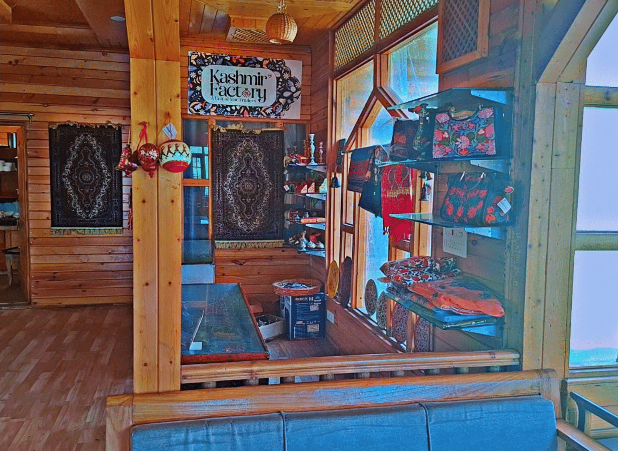 An interior gift shop area at Dawat e Drung by FrozenFall Resort, Drung, Tangmarg, featuring wood panelling, displays and large glass windows.