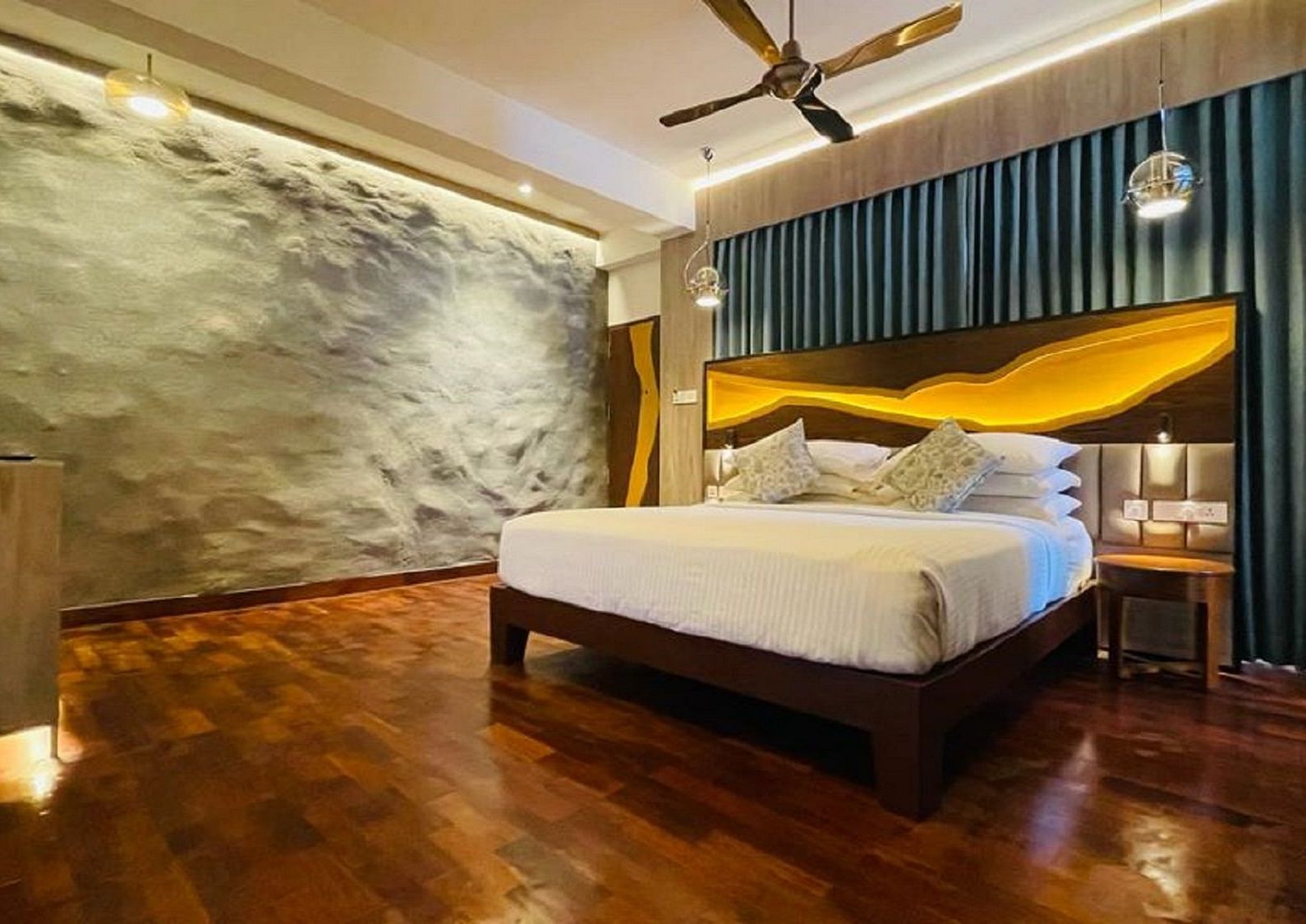 An image of timber Lodge room with a king size bed, ceiling fan, decorative items, and wall paintings - GReaT trails Kodaikanal by GRT Hotels