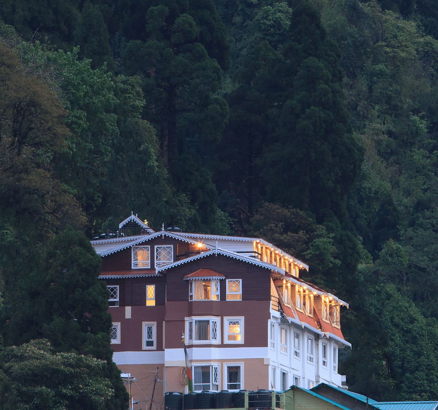 Front facade view of Summit Hermon Hotel & Spa, Darjeeling, surrounded by lush greenery