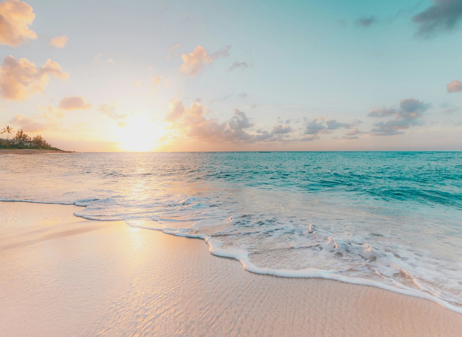 Image of a beach with the sun in the horizon.