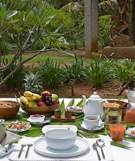 A table filled with fresh, nutritious Ayurvedic food in a lush green environment - Shreyas Retreat