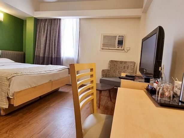 alt-text Standard room with king size bed and a table and chair at Hotel Diplomat