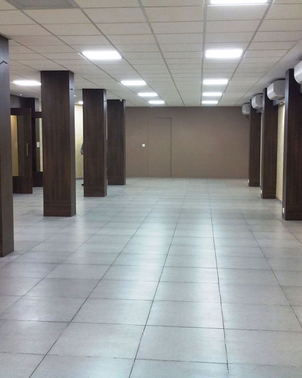 Spacious corridor or hall with tiled floor and wooden columns