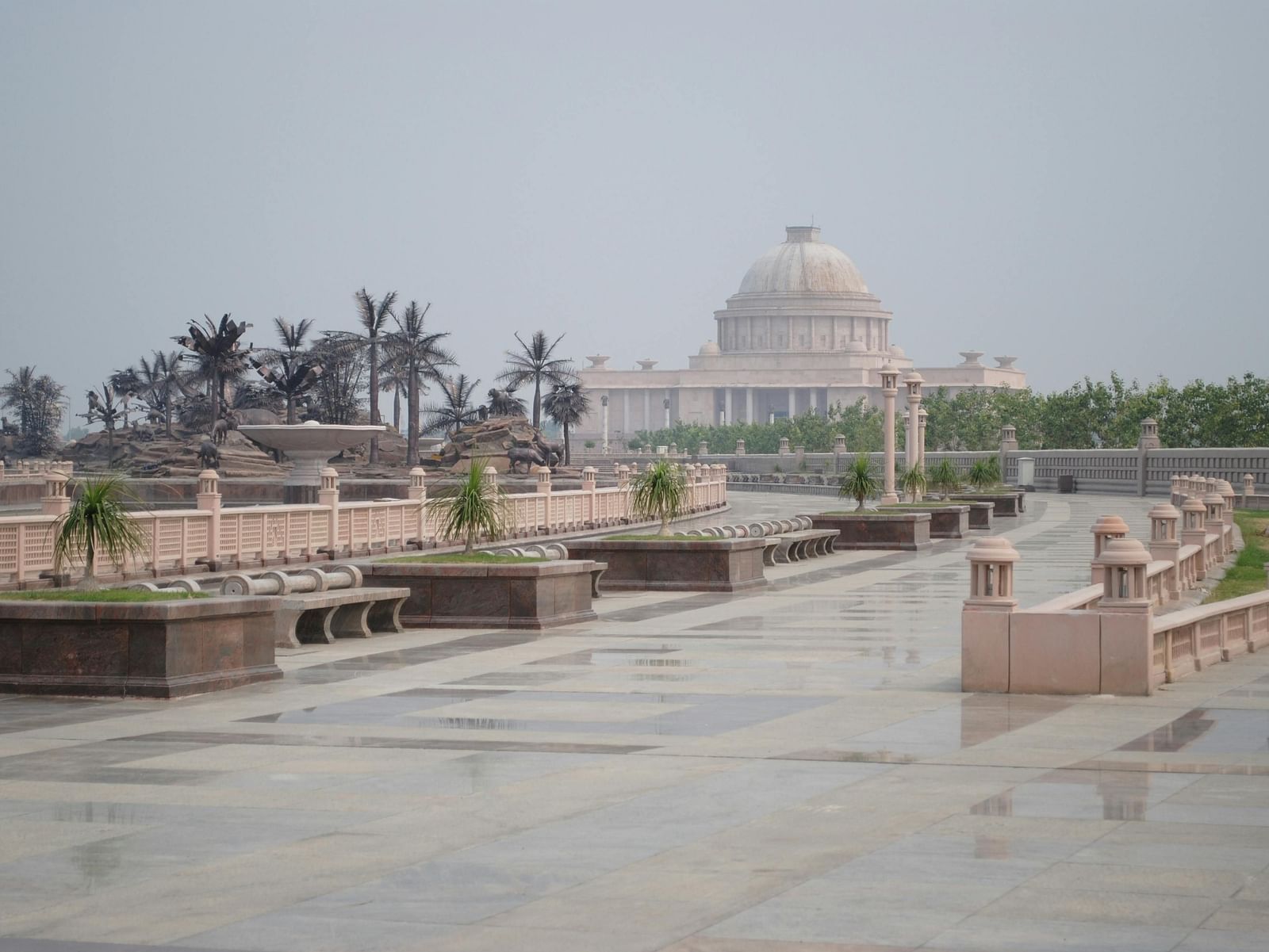 Ambedkar Memorial Park in Lucknow, showcasing grand sandstone architecture with domes, pillars, and open courtyards on a cloudy day.