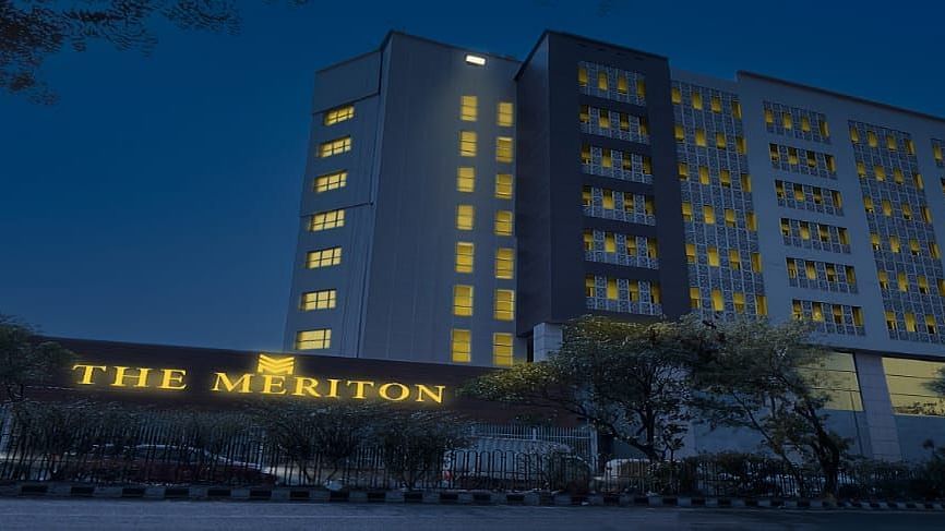 Facade shot of The Meriton in New Delhi during the night time with a well illuminated neon board in the front.