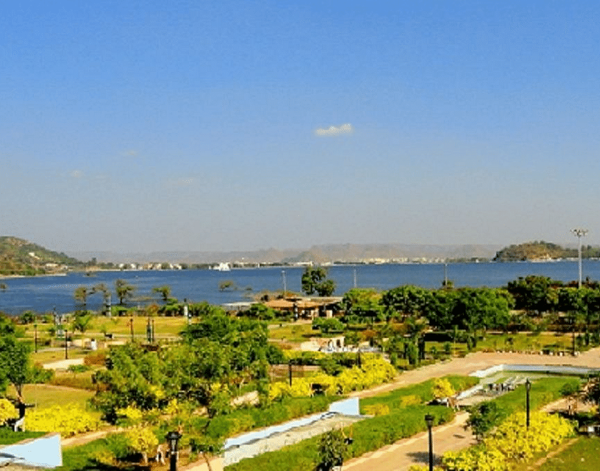 Udaipur lake view with hills, garden in foreground.