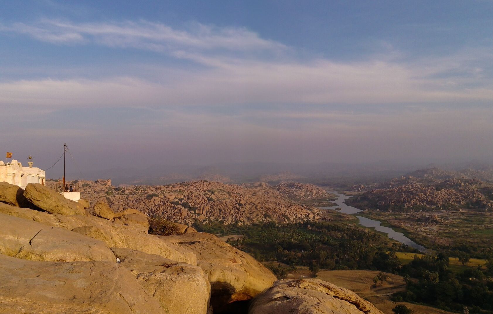 Panoramic view of Hampi with ruins and a river.