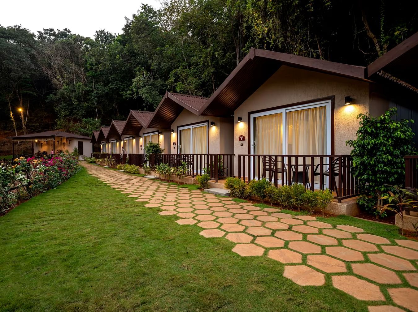 A well maintained corridor leading to the cottages illuminated by hanging lights - Stone Wood Nature Resort, Gokarna