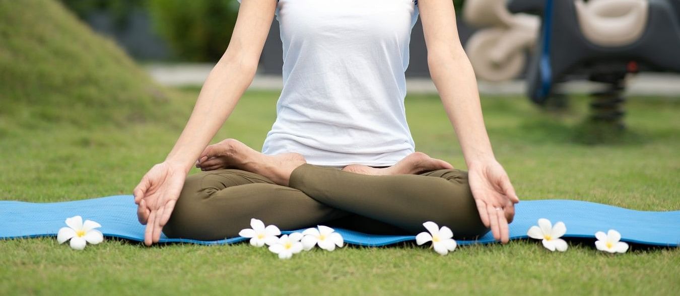 A  lady meditating in a park