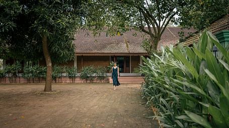 An open area where a woman is seen walking in front of a villa which is surrounded by greenery - BluSalzz Villas - Muhamma Resort, Alleppey