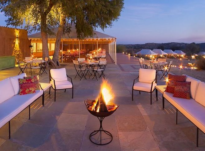 An image of the outdoor seating area with a bonfire in the middle at MANVAR Resort & Desert Camp