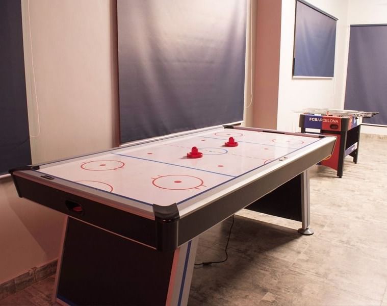 An air hockey table with two mallets placed on top at DLS Forest Vines Resort & Spa, Ramnagar (Jim Corbett).