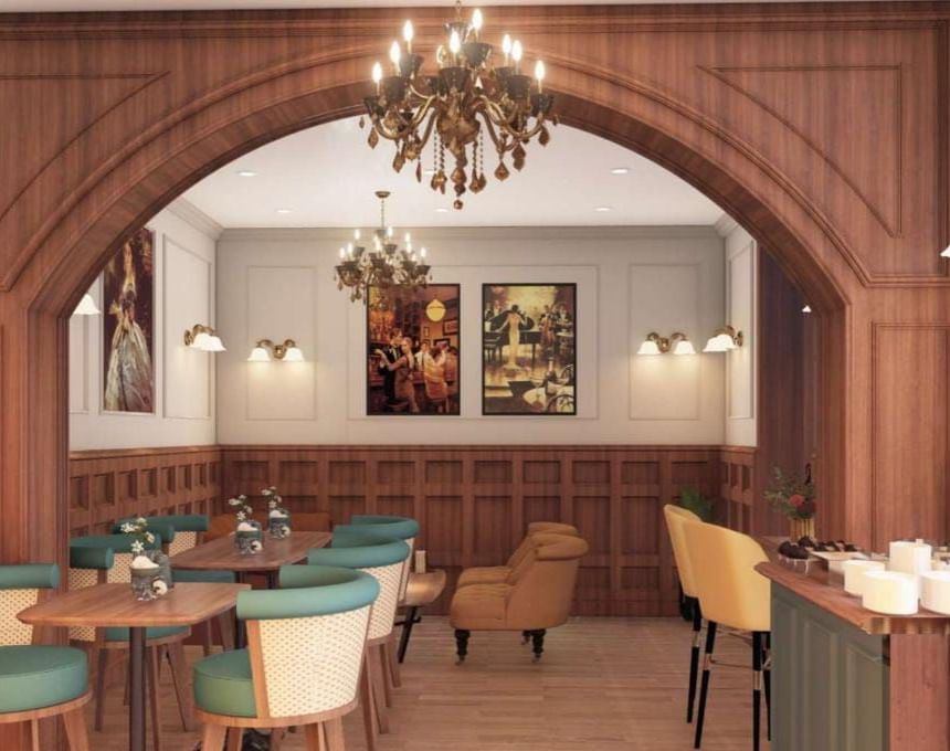 Elegant restaurant or hotel dining area featuring dark wood panelling, an arched doorway, and teal and mustard seating at BluSalzz Terrah Hills Resort, Dalhousie.