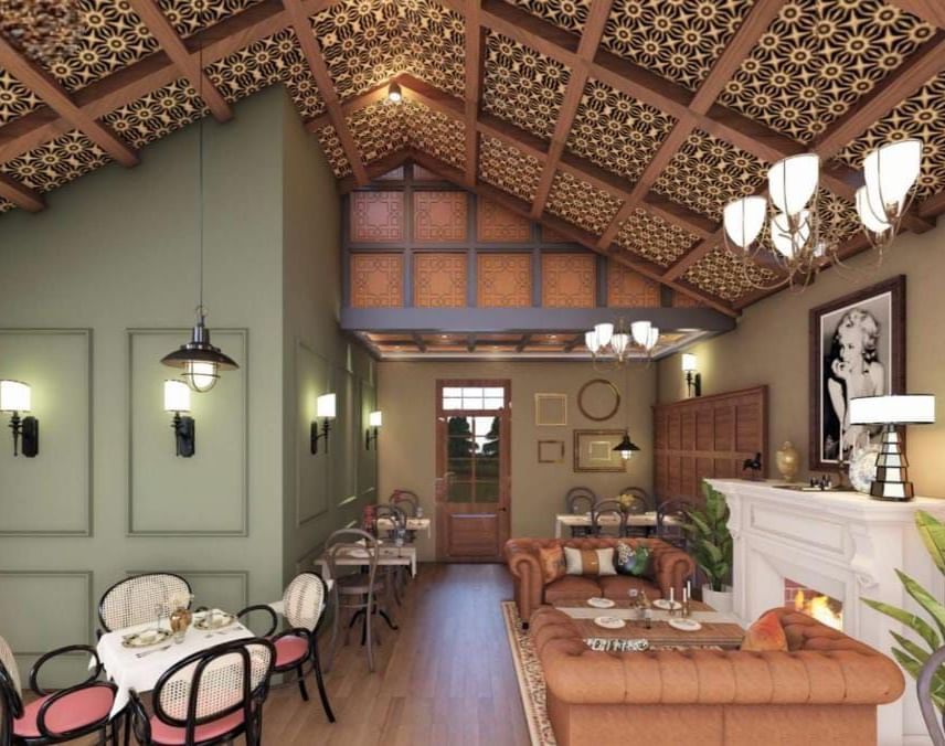 Cosy dining space featuring a high, textured ceiling, sage green accent walls, and a white fireplace at BluSalzz Terrah Hills Resort, Dalhousie.