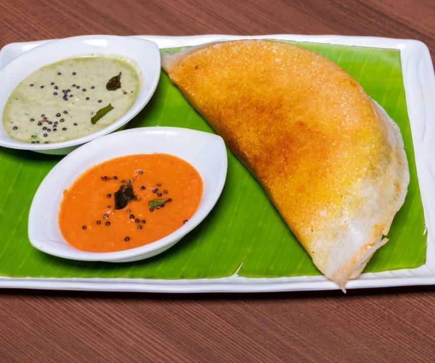A dosa on a plate with two different types of chutney from Mulbagal Dosa at Hotel Pai Viceroy Jayanagar