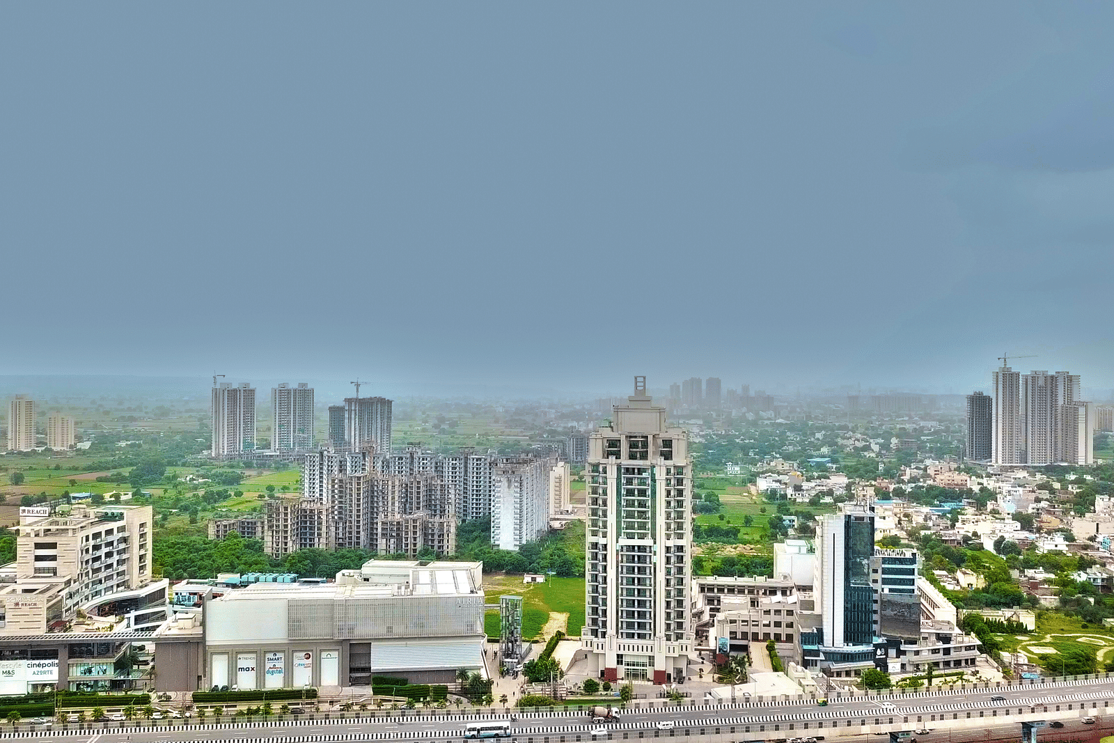 Bird's eye view of Rhythm Gurugram with other buildings and trees next to it 