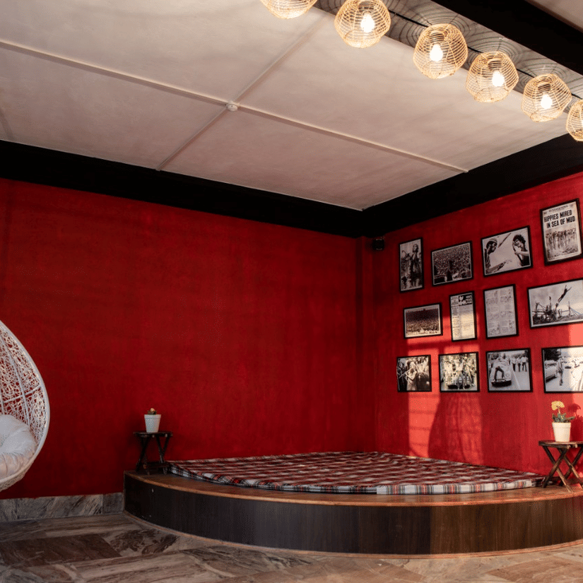 The banquet hall at Woodstock Farmhouse, Shillong, featuring a swing, lights, and wall arts.