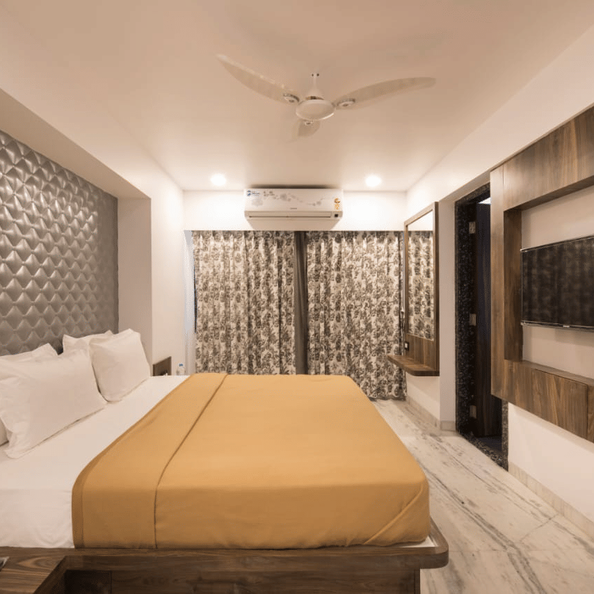 side view of deluxe room at  adamo sanmukh with its clean ambience and modern interior .