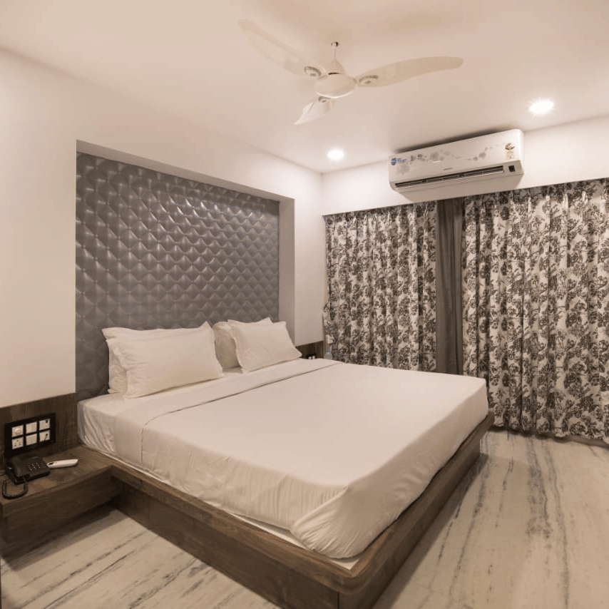 Deluxe room at  Adamo Sanmukh  with modern interior featuring a comfortable bed, modern furnishings, soft lighting, and a clean, inviting ambiance.