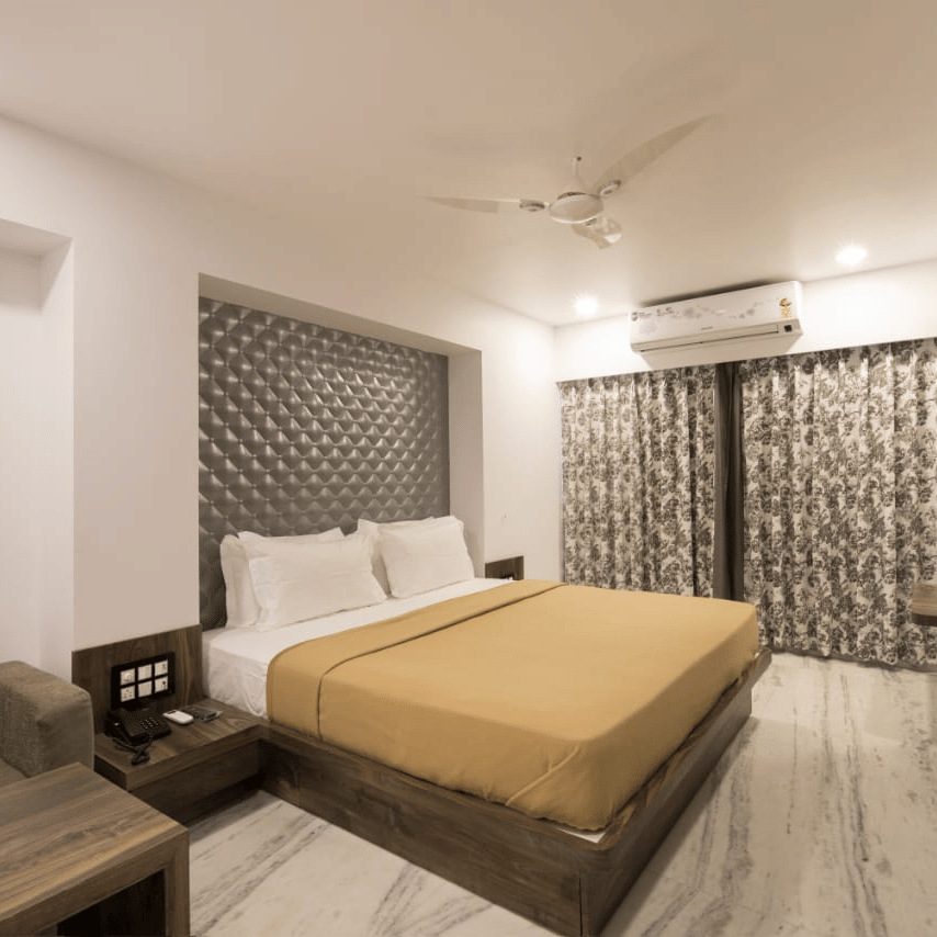 Super Deluxe room at Adamo Sanmukh with modern interior featuring a comfortable bed and clean ambience.
