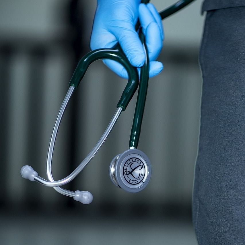 close up image of a person wearing latex gloves holding a stethoscope