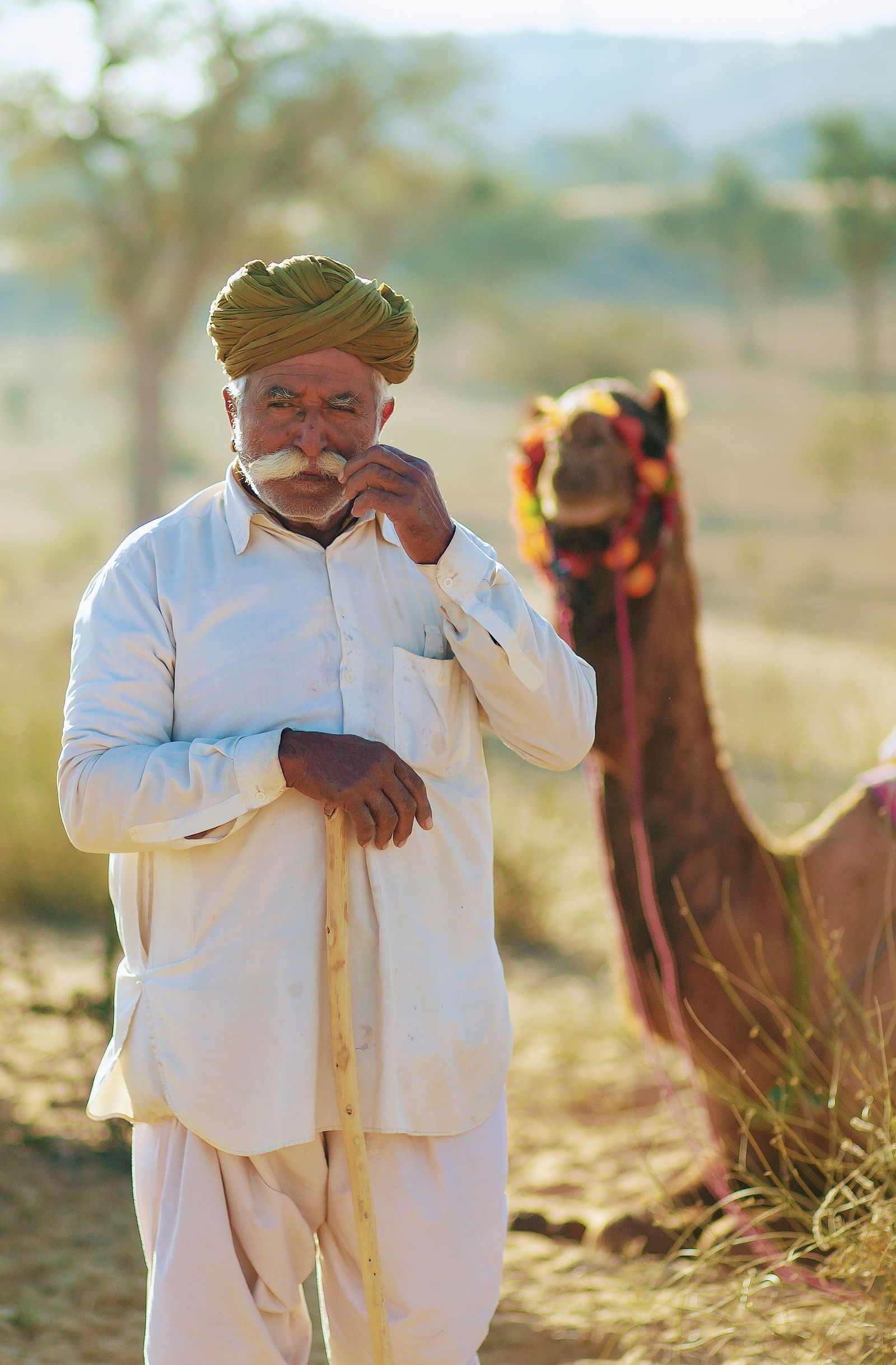 A caretaker alongside his camel in the desert