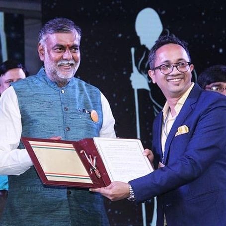 Prahlad Singh Patel presents an award at an event.