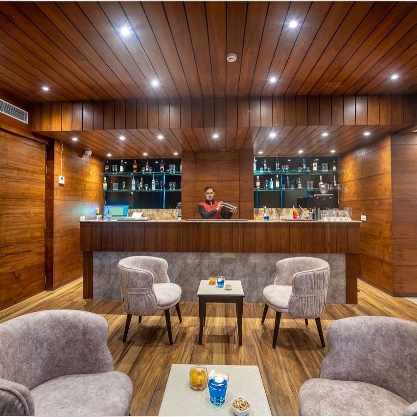 Another view of the bar area with a round central table and armchairs, creating a warm, intimate atmosphere.