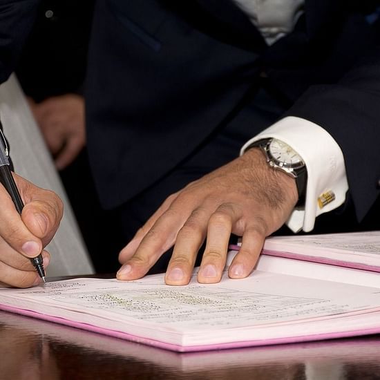 A person writing something on a register