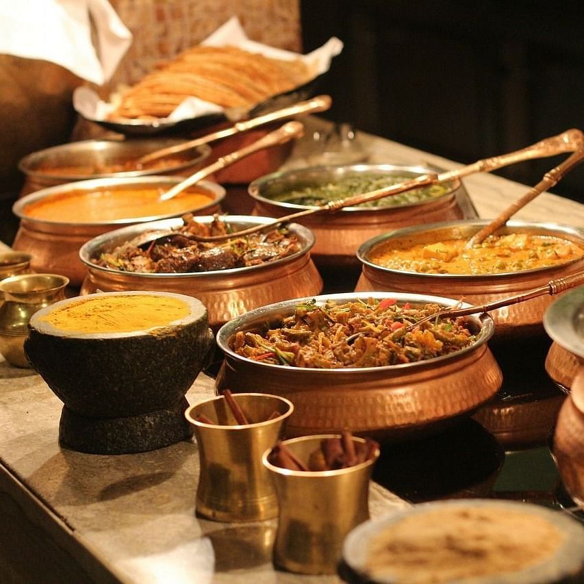 Buffet spread of GK Hill View Resort includes multiple dishes placed in copper utensils.
