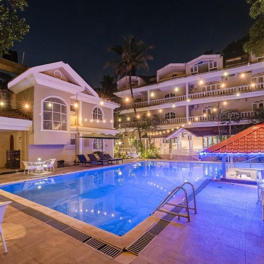 Facade of Calux Joia Do Mar Resort, Goa with a swimming pool in front.