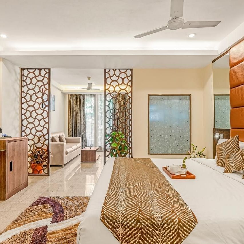 Side view of Grand Room with a bed and television in front at Calux Joia Do Mar Resort, Goa.