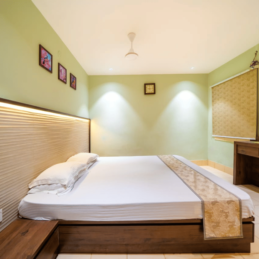 Room with a double bed, light-coloured walls, and a wall-mounted television – Hotel Dolphin Puri