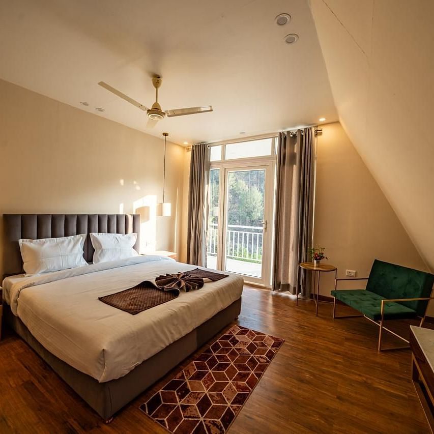 A hotel room showing a bed, a TV, and a door to the balcony.