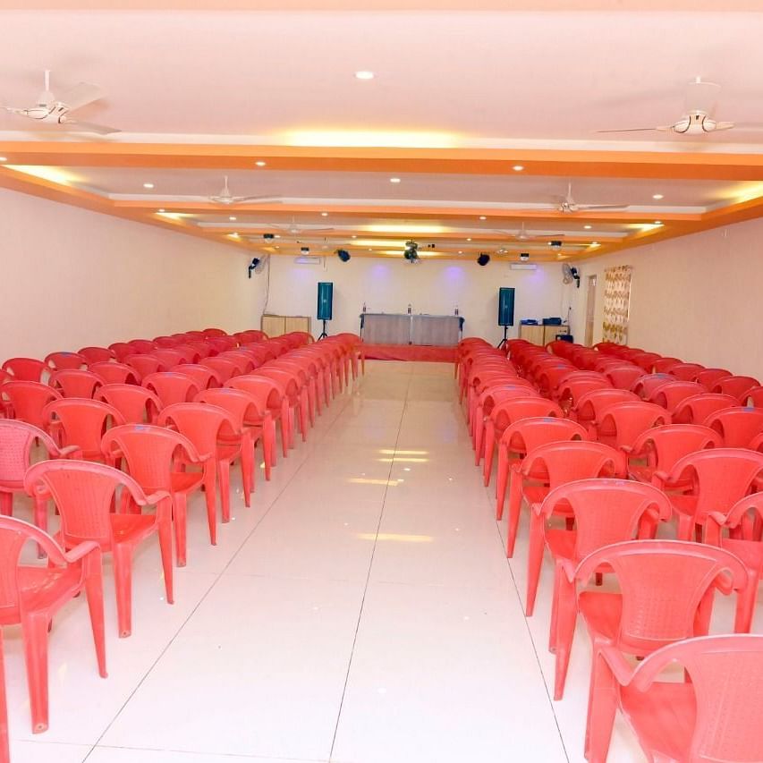 An image of the seating arrangement at the banquet hall  with a table and chairs placed on a podium at Nisarga Lake Resort