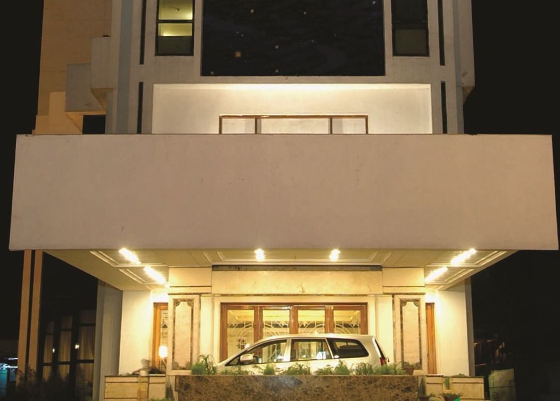 Facade of a night-time view of a modern hotel building illuminated with lights in the ground floor | Gemini Continental
