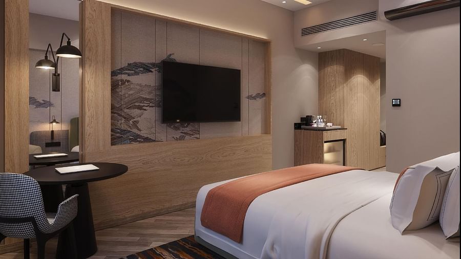 Image of a room with bed with a television in front.